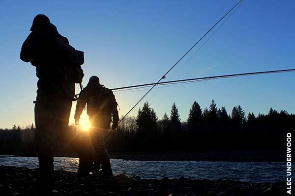 Two anglers walking at sunset.