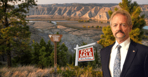 Pendley stands in front of the a for sale sign that is planted on public lands. lands in